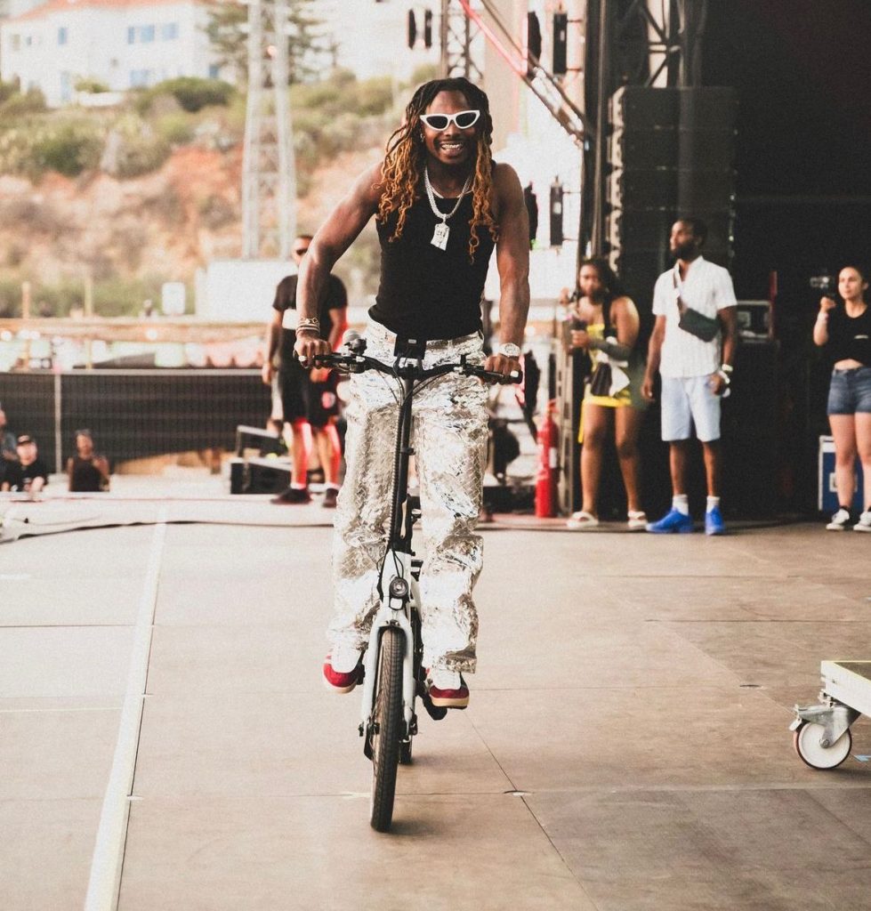 asake riding a bicycle