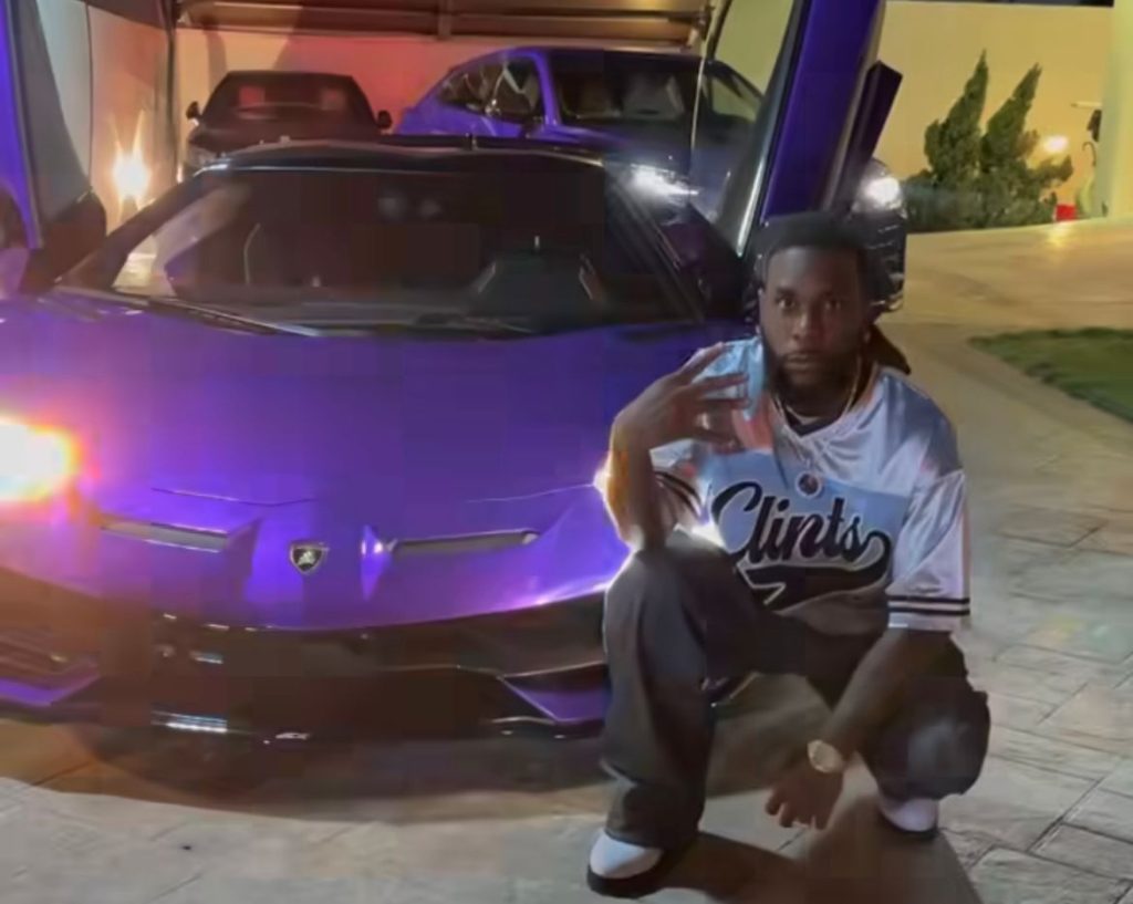 burna boy posing in his Ferrari