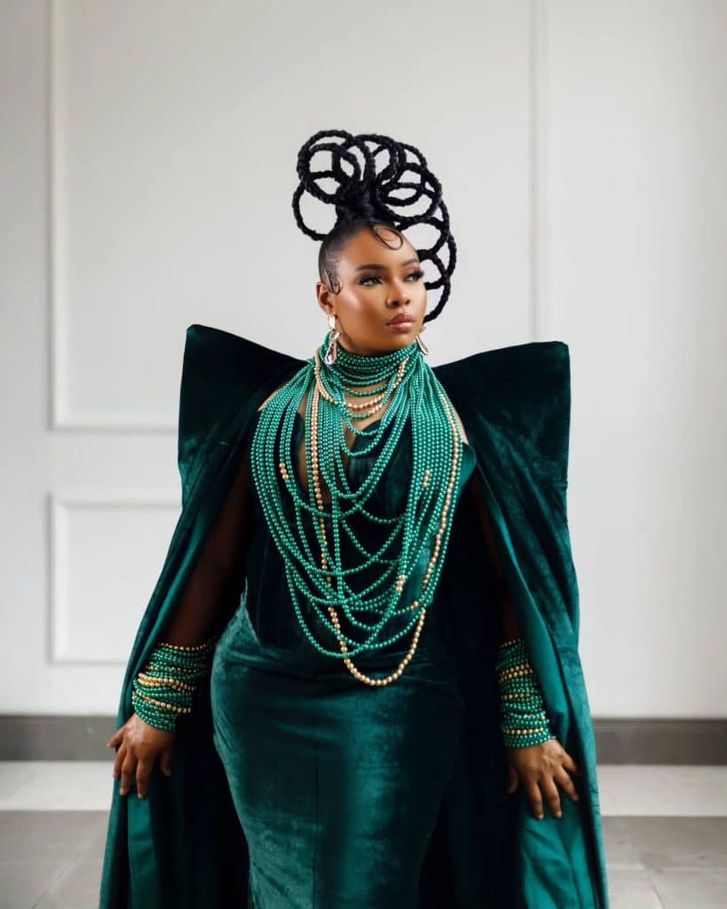 a photo of yemi alade wearing a beautiful green dress