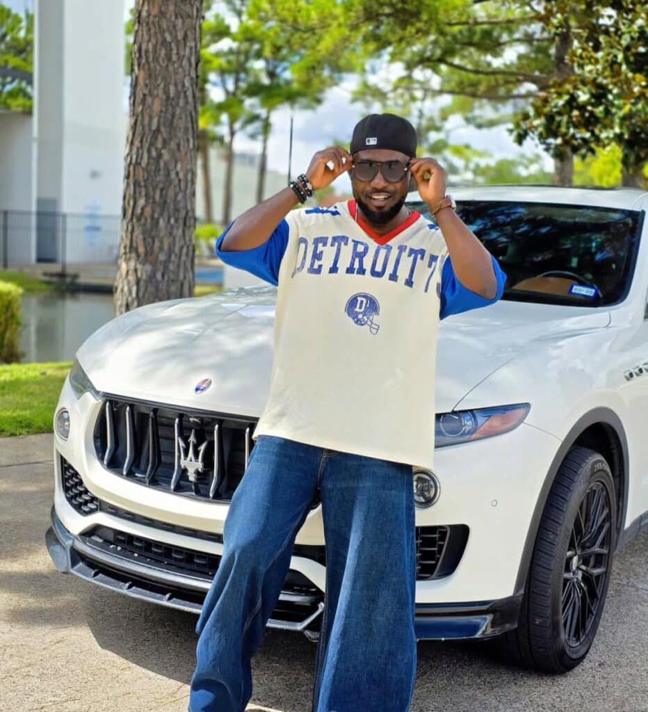 a photo of ay standing in front of his car